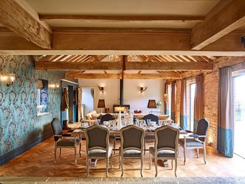 a dining room with a long table and chairs at The Fairoaks Estate in Ledbury