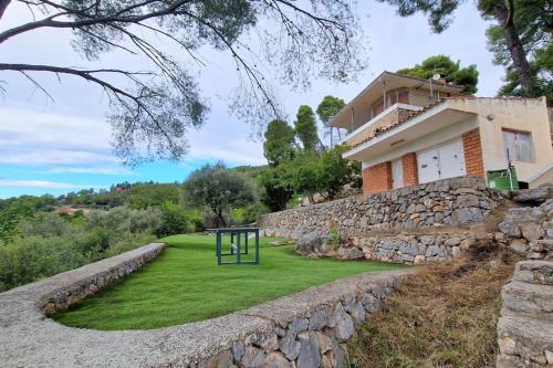 uma casa com uma parede de pedra ao lado de um quintal em casa en un parque natural em Las Villas