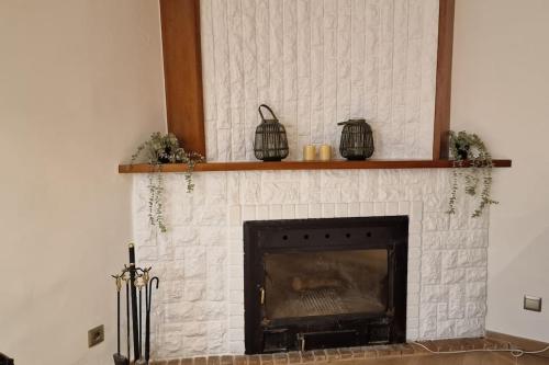 a white brick fireplace with two shelves above it at casa y piscina en un parque natural in Benicàssim