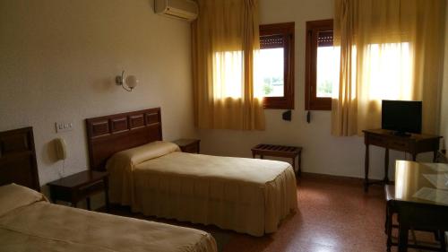 um quarto de hotel com duas camas e uma televisão em Hotel-Motel Sol II em Requena