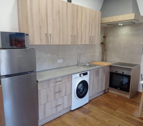 a kitchen with a refrigerator and a washing machine at Casa Rueiro in A Pobra do Caramiñal