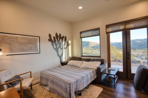 a bedroom with a bed and a couch and windows at Quails Nest Joshua Tree l Classic at Park Entrance in Joshua Tree