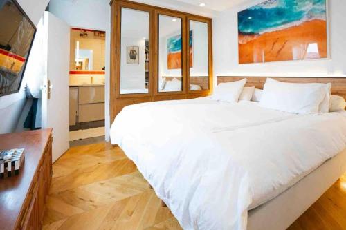 une chambre avec un grand lit blanc et une cuisine dans l'établissement Luxueuse suite, à Paris