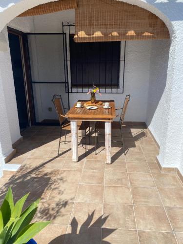 a wooden table and chairs on a patio at Bungalow Steps from Moraira in Teulada