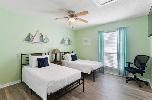 a bedroom with two beds and a ceiling fan at #250G Madeira Beach Yacht Club in St. Pete Beach