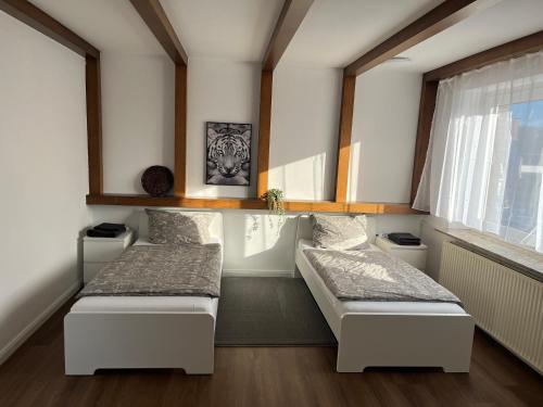 two beds in a room with a window at Weber Apartment Luisa in Bohmte