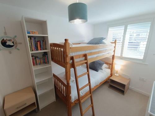 - une chambre avec des lits superposés et une étagère à livres dans l'établissement Ideal Brighton Escape ,Cosy & Free Parking- Matt House, à Brighton et Hove