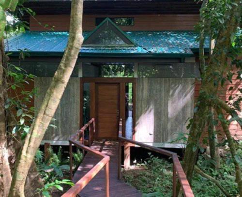 a small house with a wooden door in the woods at Cabaña Bosquemar 1 in Agujas