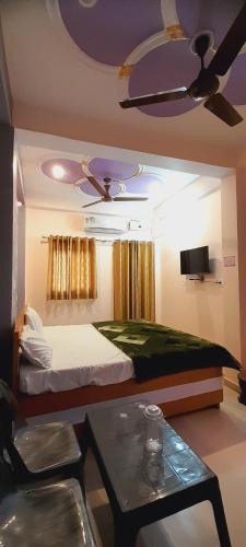 a bedroom with a bed and a ceiling fan at Shiv Niketan Guest House 200mtr from Shri Ram mandir in Ayodhya