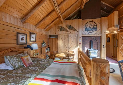 um quarto com uma cama num chalé de madeira em Buffalo Bliss by KABINO Riverfront Firepit Partial A/C Huge Views WiFi em Island Park