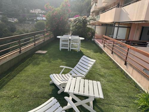 une rangée de chaises et de tables blanches sur un balcon dans l'établissement Havre de paix MONACO, à Beausoleil