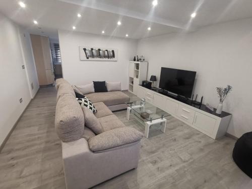 salon z kanapą i telewizorem z płaskim ekranem w obiekcie A CASA DO LADO w mieście Noya