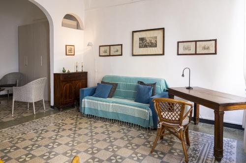 een woonkamer met een blauwe bank en een tafel bij Arcani Family Apartment by Wonderful Italy in Finale Ligure