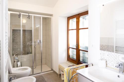 een badkamer met een toilet, een wastafel en een douche bij Arcani Family Apartment by Wonderful Italy in Finale Ligure