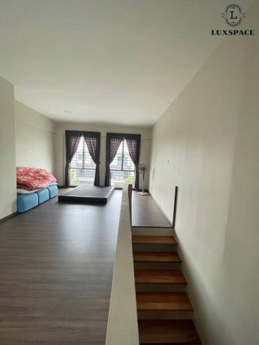 a large room with a bed and a staircase at Cozy Kuching Samarahan Townhouse in Kota Samarahan