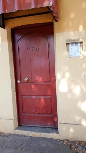 uma porta vermelha num edifício com o número em hostal RV em Temuco