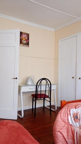特木科的住宿－hostal RV，一间卧室配有一张桌子和一张椅子,位于床边