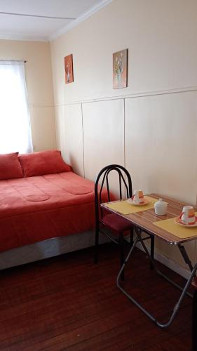 Cette petite chambre comprend un lit et une table basse. dans l'établissement hostal RV, à Temuco