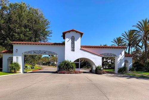 a large white building with a gate and palm trees at Luxury Villa at Omni La Costa Resort & Spa in Carlsbad