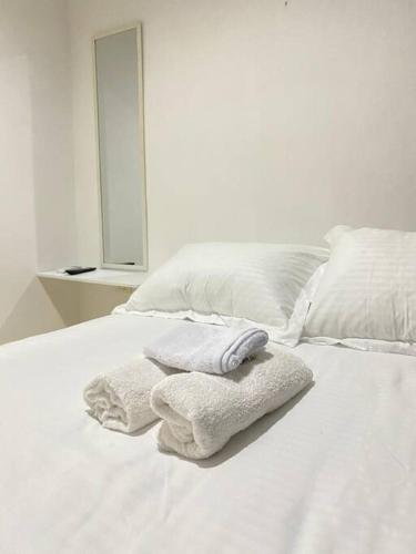 uma cama branca com toalhas por cima em Apartamento cómodo cerca al aeropuerto em Cartagena de Indias