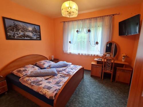 um quarto com uma cama, uma secretária e uma janela em Ferienhaus am Aalkasten em Alt Zeschdorf