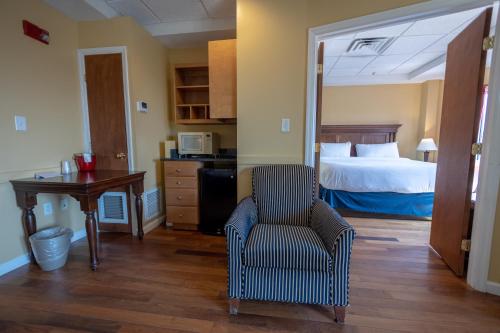 a bedroom with a bed and a chair and a desk at Ocean Inn & Suites in Saint Simons Island