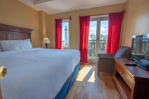 a bedroom with a bed and a desk with a television at Ocean Inn & Suites in Saint Simons Island