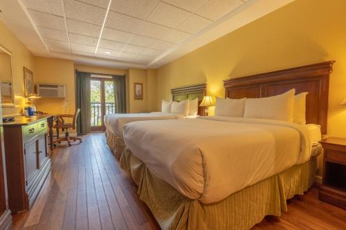 two beds in a hotel room with yellow walls at Ocean Inn & Suites in Saint Simons Island