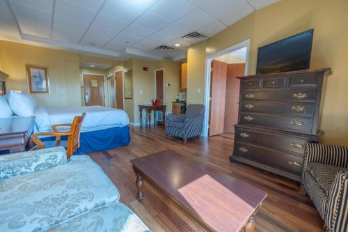a bedroom with a bed and a dresser with a tv at Ocean Inn & Suites in Saint Simons Island