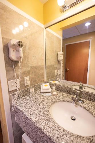 a bathroom with a sink and a large mirror at Ocean Inn & Suites in Saint Simons Island