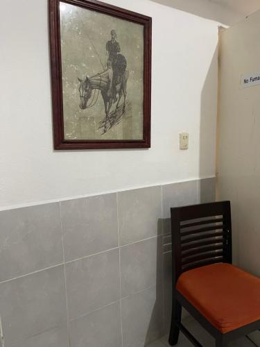 a painting of a man riding a horse on a wall at Hotel Cupules in Mérida