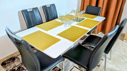 uma mesa com cadeiras pretas e uma mesa branca com mesa amarela em Timba-Pekin em Cotonou