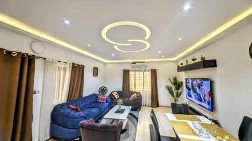 uma sala de estar com um sofá azul e uma televisão em Timba-Pekin em Cotonou