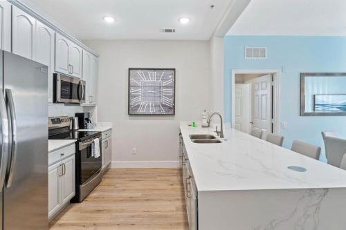 a kitchen with white counter tops and a refrigerator at The Epic London Vista Cay Orlando Next to the club in Orlando