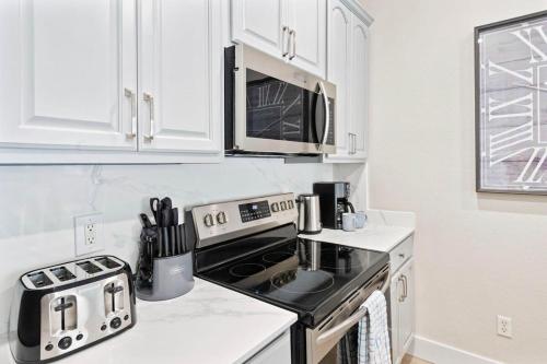 a kitchen with a stove and a microwave at The Epic London Vista Cay Orlando Next to the club in Orlando