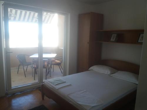una camera con letto e tavolo con sedie di Apartments by the sea Podgora, Makarska - 2615 a Podgora