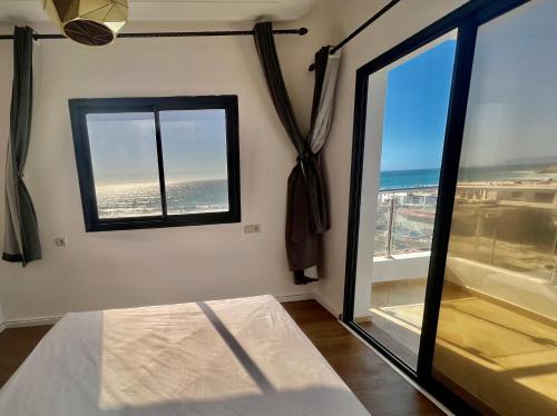 a bedroom with a view of the ocean from a window at Baya House Sea View in Agadir