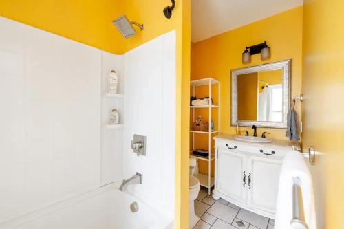 a bathroom with yellow walls and a tub and a sink at Bright Spacious Apartment - 2 BR 2 BA in Portland