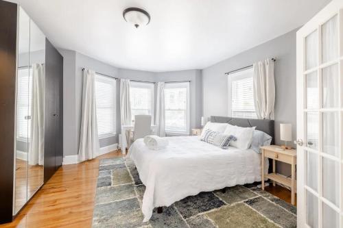 a bedroom with a white bed and windows at Bright Spacious Apartment - 2 BR 2 BA in Portland