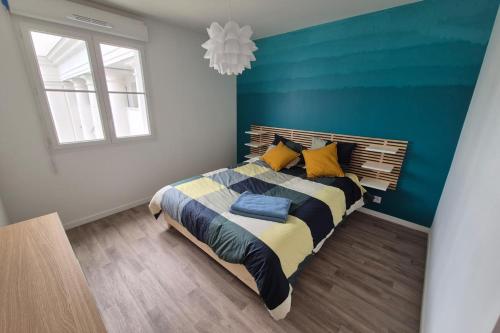 een slaapkamer met een bed met een blauwe muur bij Disneyland Sky Haven - 5min to Disneyland in Serris