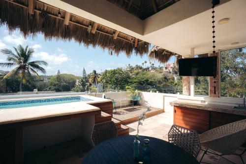 a swimming pool with a view of a house at Nuiya Hoteles Centro in Sayulita