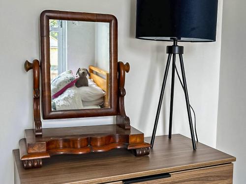 a mirror on top of a dresser next to a lamp at Apartment 5 - Uk42736 in Whitstable