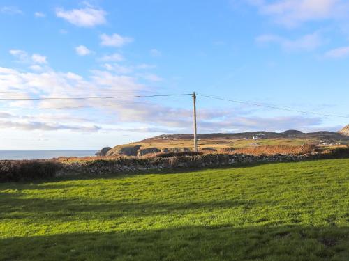 een grasveld met een telefoonpaal en de oceaan bij Uk46570 - Awel Y Mor in Holyhead