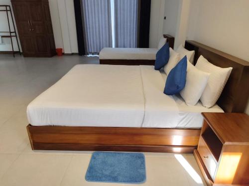 - une chambre avec un lit doté d'oreillers bleus et blancs dans l'établissement Villa Vyoma, à Talpe
