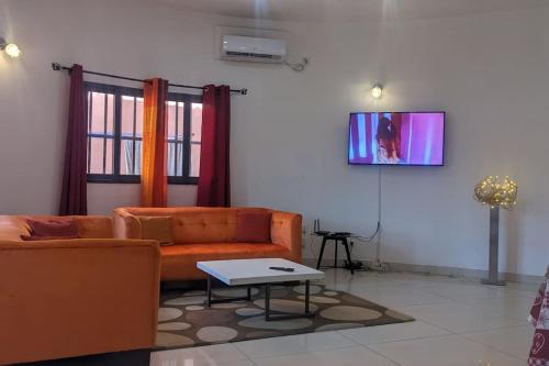 uma sala de estar com um sofá e uma mesa em Élégante villa avec jardin+bar em Lomé