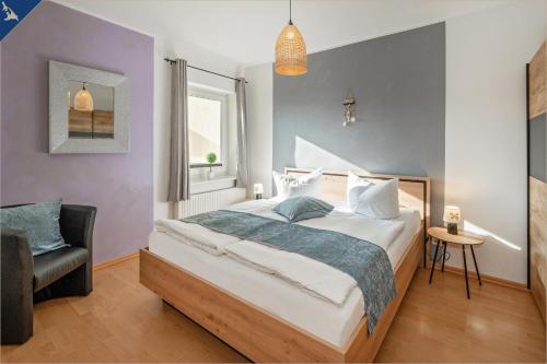 ein Schlafzimmer mit einem großen Bett und einem Stuhl in der Unterkunft Villa Linde FeWo 2 in Ahlbeck