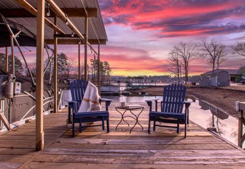 2 chaises et une table sur un quai avec un coucher de soleil dans l'établissement Canary's Nest, à Hot Springs