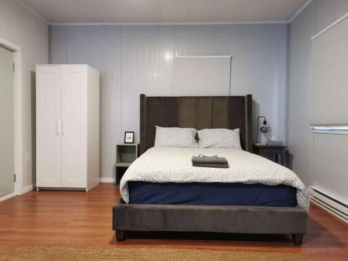 1 dormitorio con 1 cama grande y cabecero de madera en Seaside Serenity: Seal Bay Glamping Retreat,Studios, en Powell River