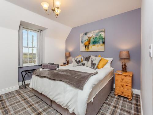 a bedroom with a large bed and a window at The Servants Quarters - Uk46339 in Canisbay