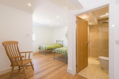 a bathroom with a bed and a toilet and a chair at Trippet Cottage in Saint Breward